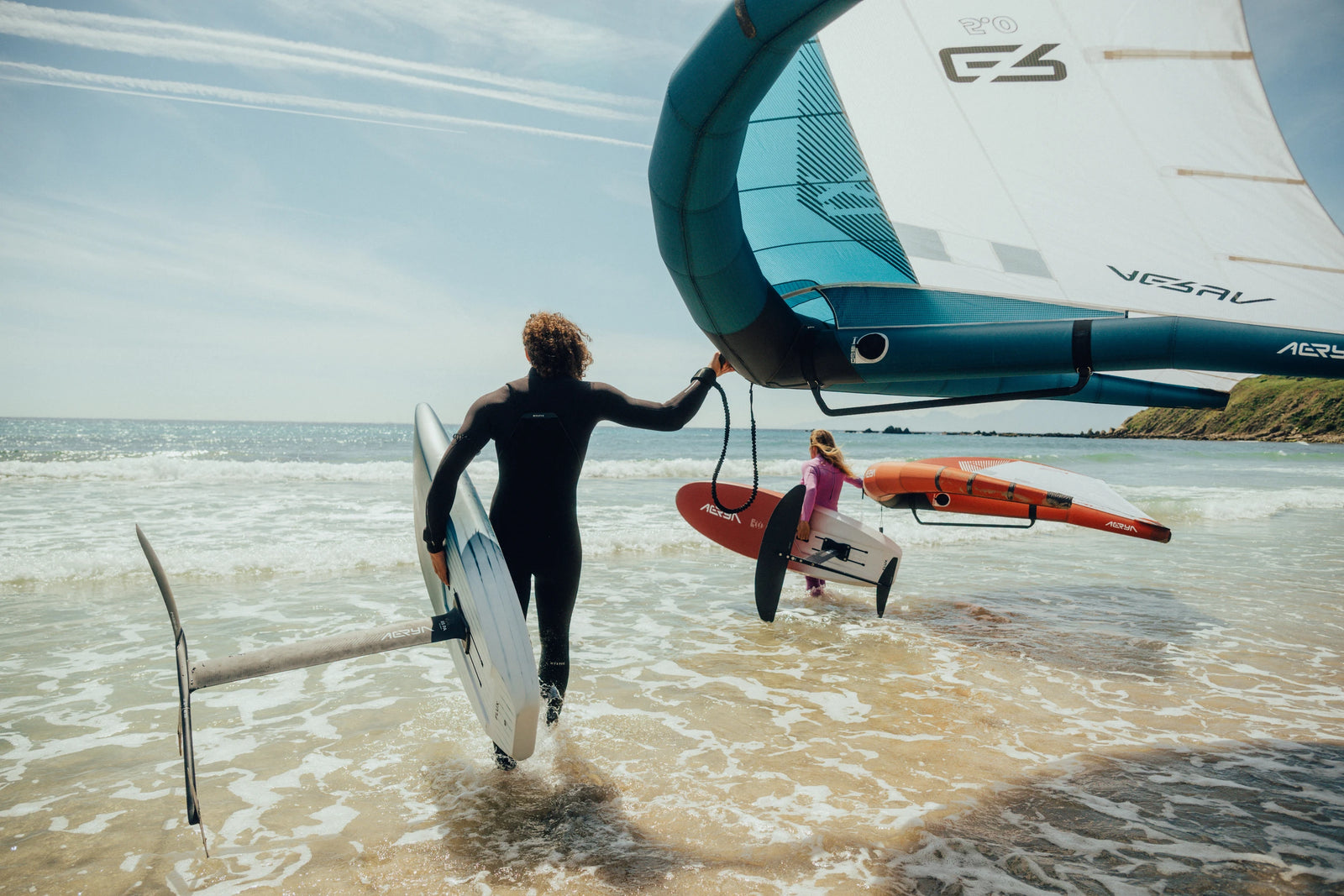Aeryn rider carrying wing and board at shore